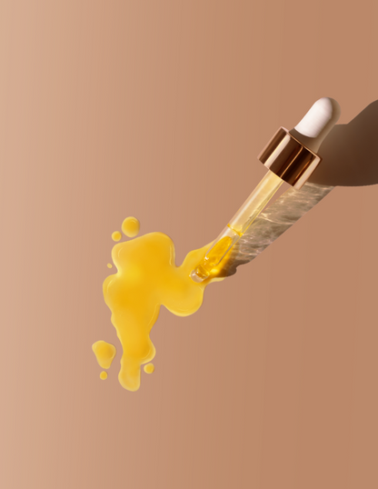 Yellow liquid being dripped from a dropper onto a beige background